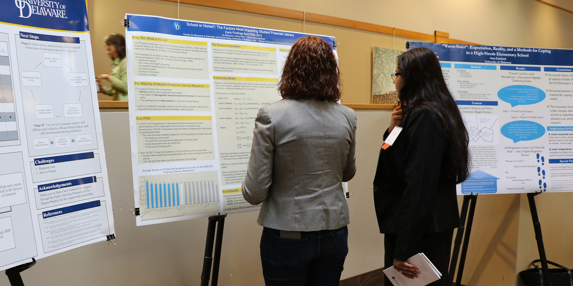 Two students review research poster at Steele Symposium