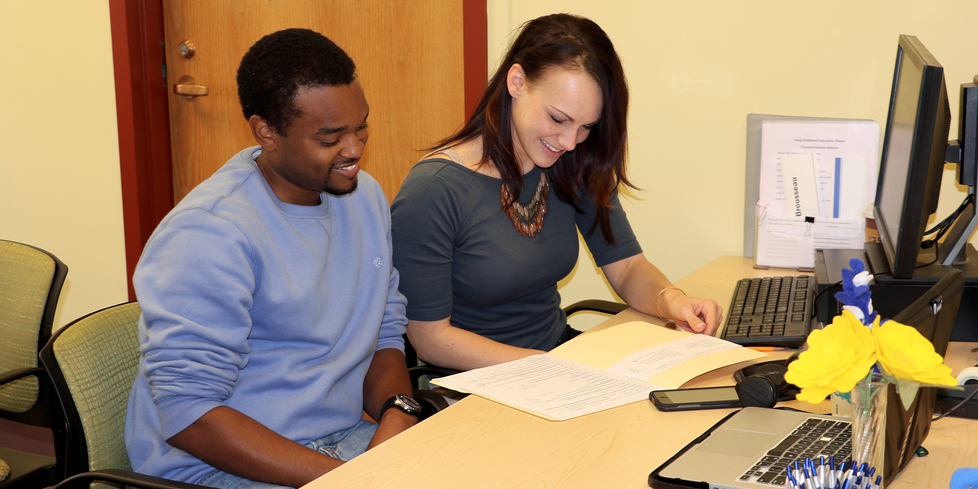 Student talks with woman at desk