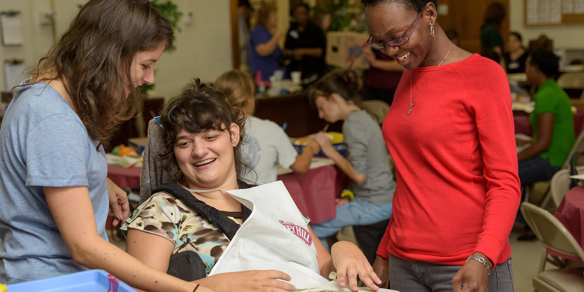 Two students assist a disabled woman during Artfest