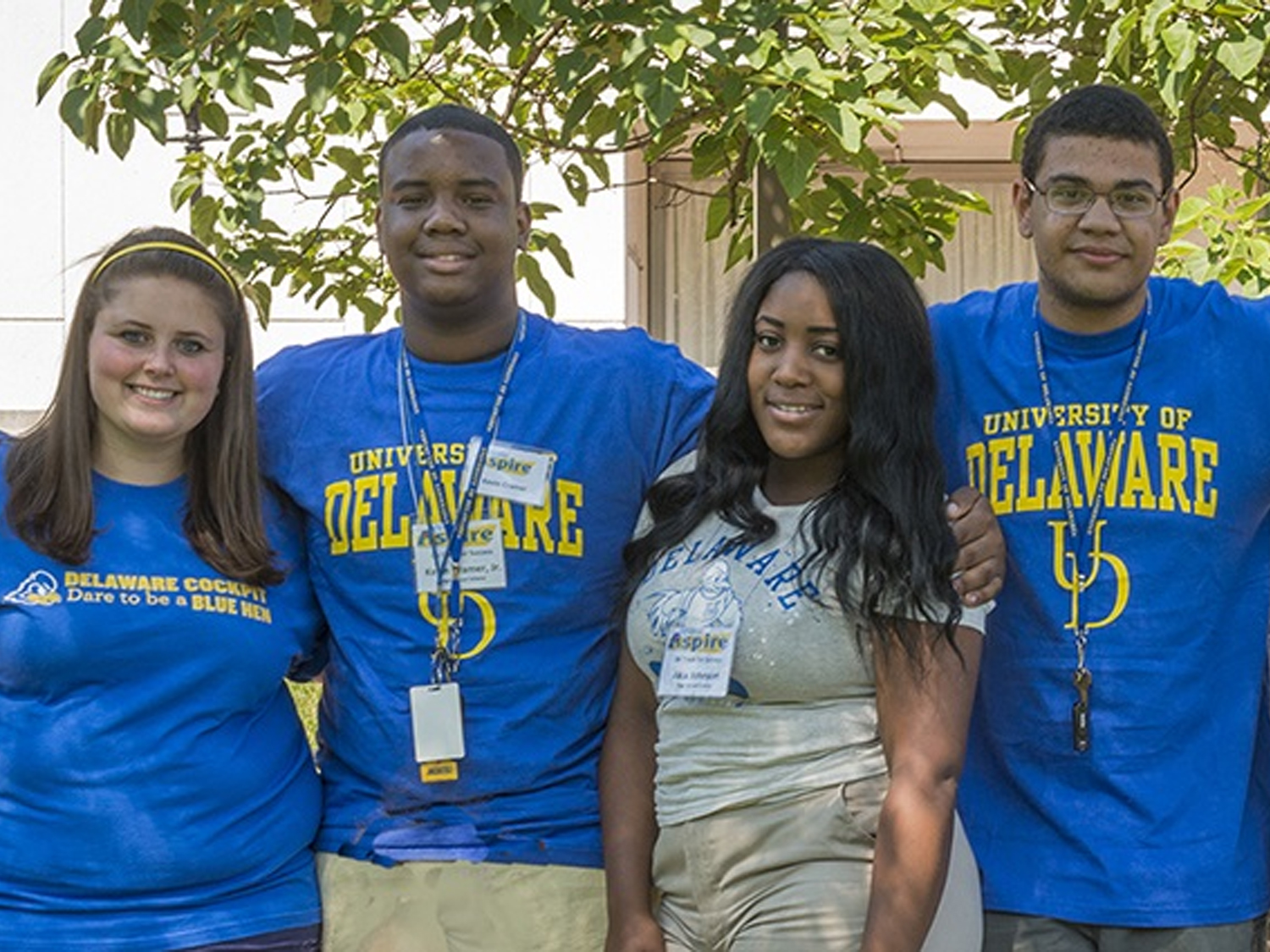 Four members of Kappa Delta Pi pose outside a campus building.