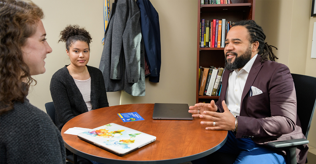 Dr. Roderick Carey speaks with two students