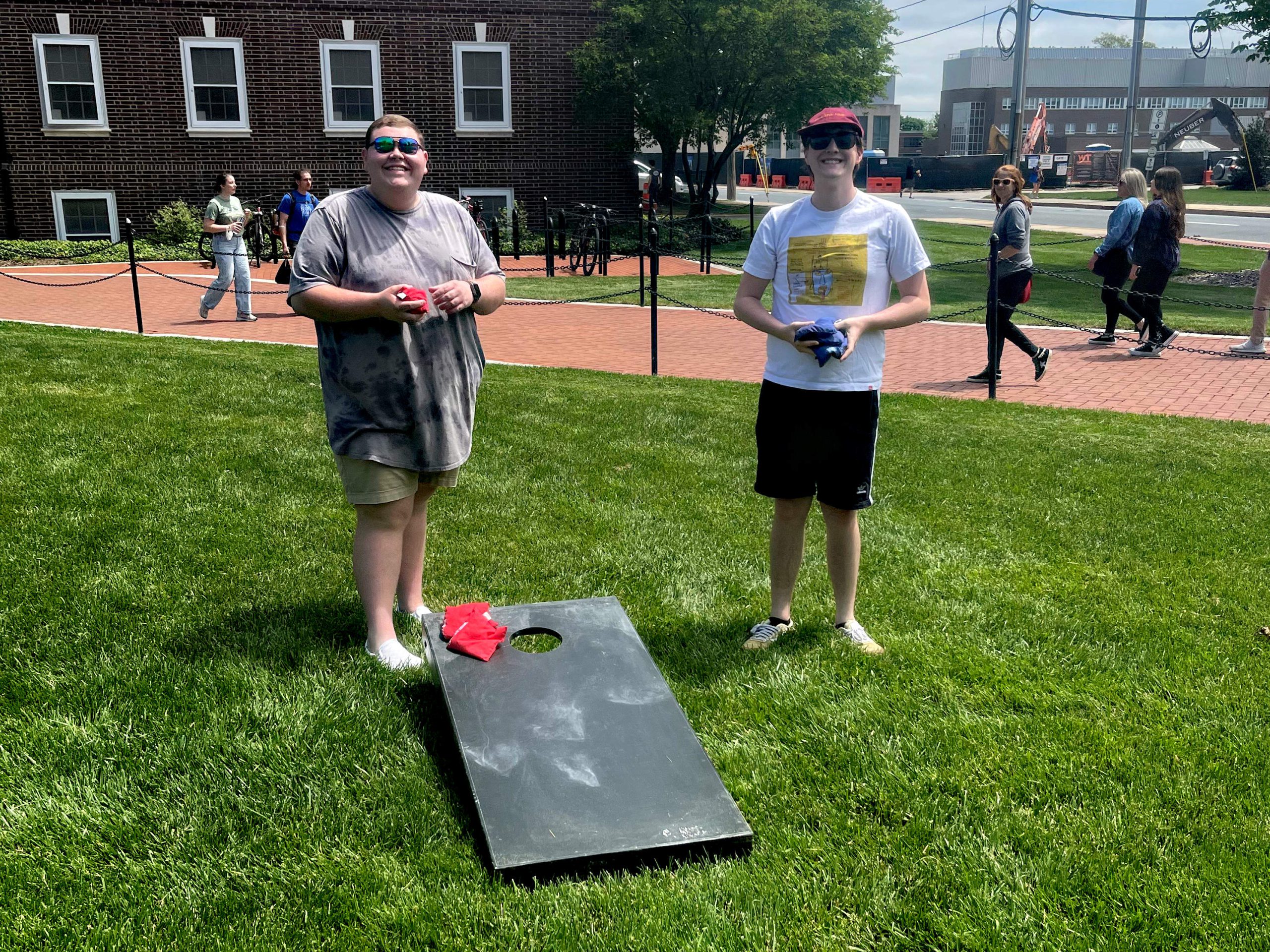TUA members play cornhole at an event on the green.